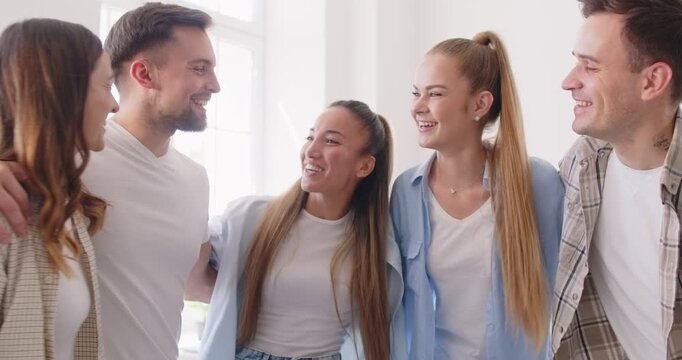 Diverse and happy group of friends embracing each other, sharing laughter and happiness during a house party. Their friendship and togetherness create a warm and joyful atmosphere in the crowd.