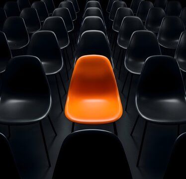 Lone orange chair in a dark auditorium a hollogram of individuality and isolation