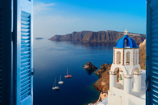 white church belfry with blue dome and volcano caldera with sea landscape, beautiful details of Santorini island, Greece
