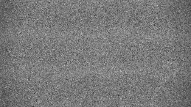 Static noise on a television screen with no signal or reception, displaying a grainy, distorted image.