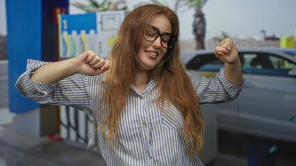 Woman raises forearms in a playful stretch at street petrol station forecourt while smiling softly  joy. © Krakenimages.com