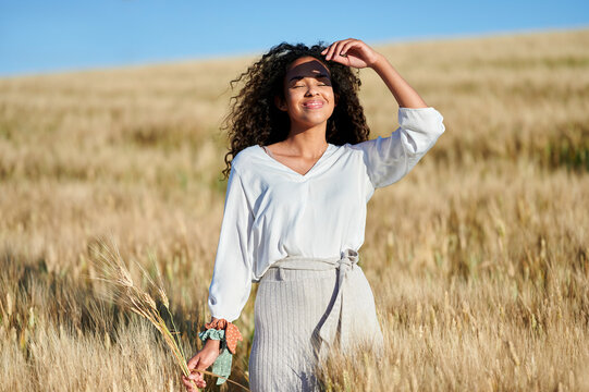 Young woman enjoying sunshine in wheat field