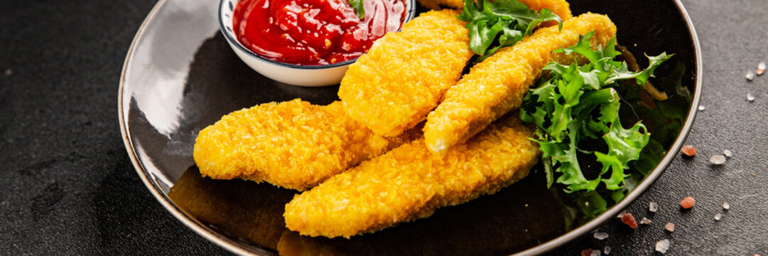 chicken strips deep-fried chicken meat aiguillettes fast food lunch or dinner tasty snack fresh, delicious, gourmet food background on the table, rustic food, top view, copy space