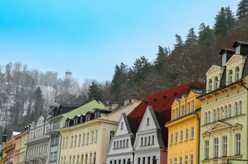 Obraz premium Karlovy Vary (Karlsbad) colorful houses and historic architecture in Czech Republic spa town winter cityscape with forest and tower