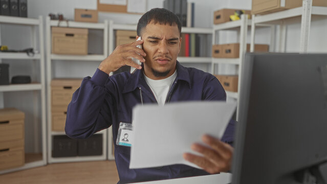 Man detective holds phone to ear while reading a document with visible badge in office building; procedural concern focus.