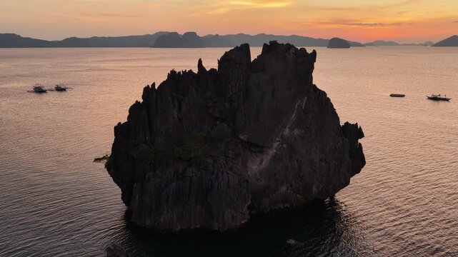 Sunset silhouettes the idyllic islands within Bacuit Archipelago, near El Nido, Philippines. This beautiful area is a popular vacation destination due to its coral reefs, beaches, and hidden lagoons.