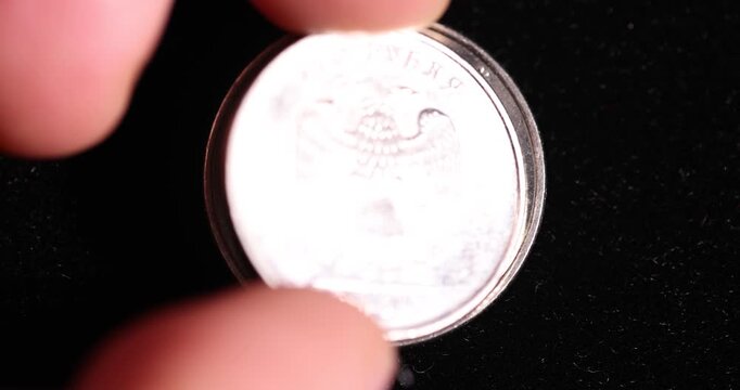 small-denomination Russian coins on a black surface, official money worth 5 rubles of the Russian Federation lies on a black surface, close up