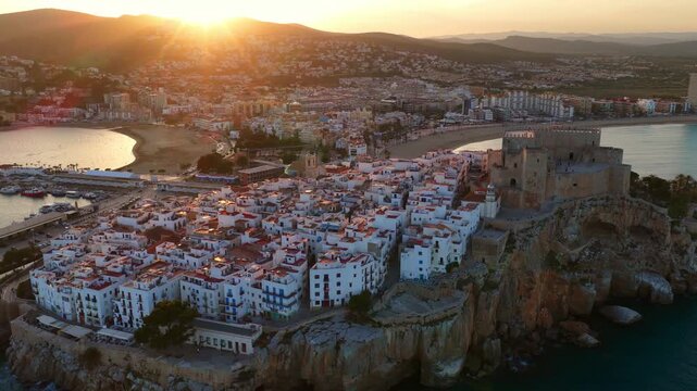 Peniscola holiday town in Valencia, Spain, drone shot of sunset in Peniscola, aerial view of Castle of Peniscola on a cliff over the Mediterranean, vacation in Spain