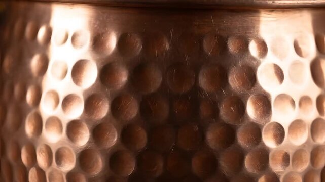 Closeup of Hammered Copper Pot Texture with Reflective Light Patterns 1.