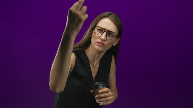 Woman wearing glasses and a sleeveless black vest holding a takeaway coffee cup while raising her middle finger in a studio purple backdrop; defiance protest boldness.