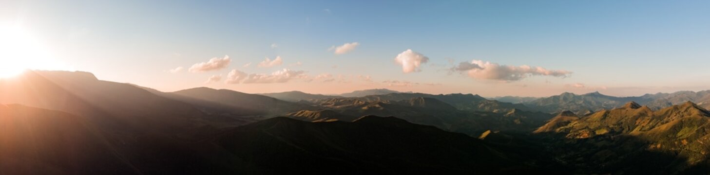 Fotografia a&eacute;rea panor&acirc;mica da Serra da Mantiqueira, Minas Gerais, Brasil, com p&ocirc;r do sol dourado iluminando montanhas, paisagem natural cinematogr&aacute;fica ideal para turismo, viagem e natureza.