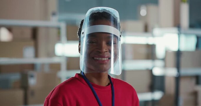 Multi-Ethnic Couple of Post Office Workers Working during Pandemic. Cheerful African Girl Wearing Protective Face Shield Smiling to Customer. Coronavirus Concept.