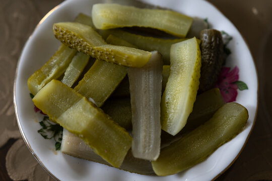 Green cucumbers sliced lengthwise on a small plate.