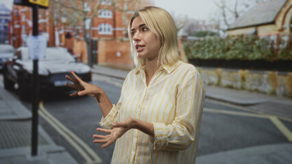 Fototapeta premium Woman uses hands to gesture on a street, showing open palms and animated hand movements; discussion concern.