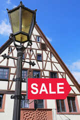 Obraz premium Sign for sale outside a building in a town with a clear blue sky