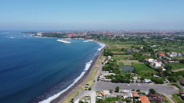 Cinematic aerial drone panning right from the coastline toward the mainland at Taman Festival Bali in Sanur, Indonesia.