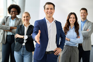 Obraz premium Portrait of happy male CEO offering a handshake in the office and looking at camera