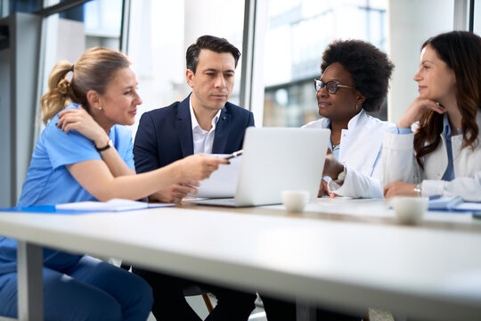 Mid adult businessman having a meeting with group of doctors in hospital