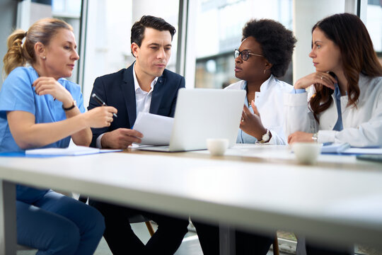 Mid adult businessman having a meeting with group of doctors in hospital