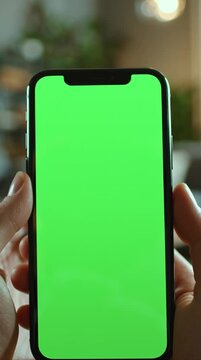 POV shot showing only hands holding a modern iPhone, screen facing viewer with bright green chroma key, smooth push-in motion, cinematic human perspective, static camera.