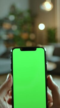 POV shot showing only hands holding a modern iPhone, screen facing viewer with bright green chroma key, smooth push-in motion, cinematic human perspective, static camera.