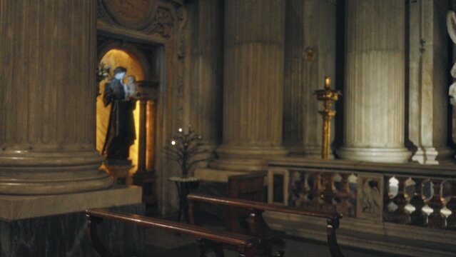 Blurred church nave with shallow bokeh, defocused ornate columns, marble pillars and wooden pews softly out of focus; background backplate copyspace calm.