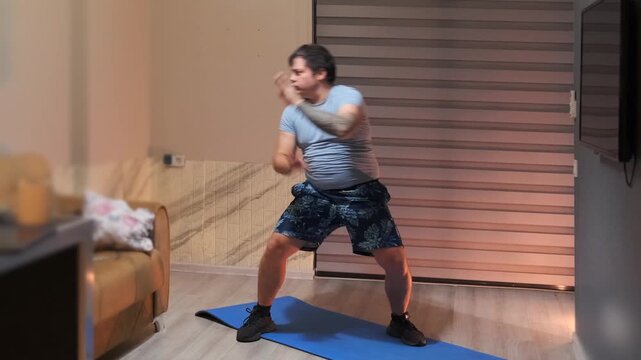 Man performing shadow boxing punches at home, dynamic cardio workout improving endurance, coordination and fat burn, fitness training routine for active lifestyle in indoor environment