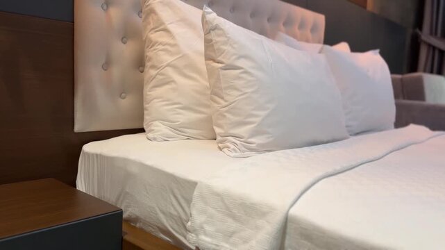 Hotel bedroom interior with white bed linens and tufted headboard, suitable as background