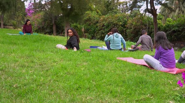 Group of multi generational women doing yoga stretching exercise with teacher at park - Multiracial people, healthy lifestyle and conscious concept