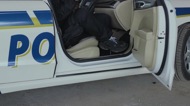 Serious two men cops come out of the patrol car stand near accepting emergence call enforcement talk look around officer police uniform auto safety security colleagues control policeman slow motion