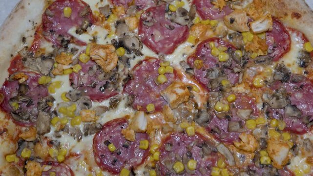 whole pizza top view with mixed toppings cheese salami corn and herbs, baked dish context