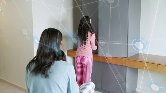 Woman in pink touching cabinet opening wardrobe presenting coat to friend while AR guiding fashion