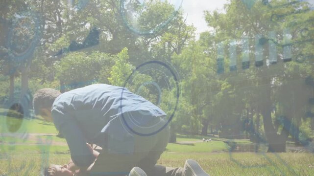 Family boy climbing onto dad sparking play wrestling, dad lifting, ring overlay hovering in park