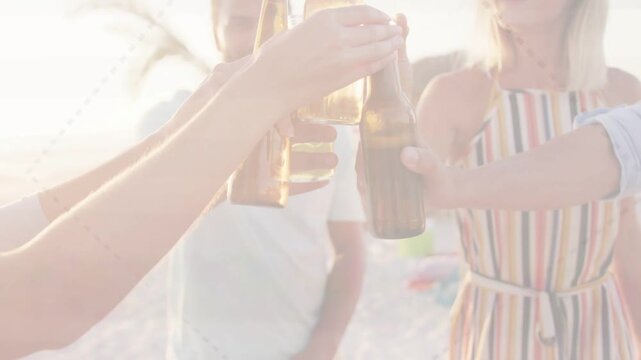 Five friends approaching beach, raising beer bottles and clinking in sunset toast, showing travel