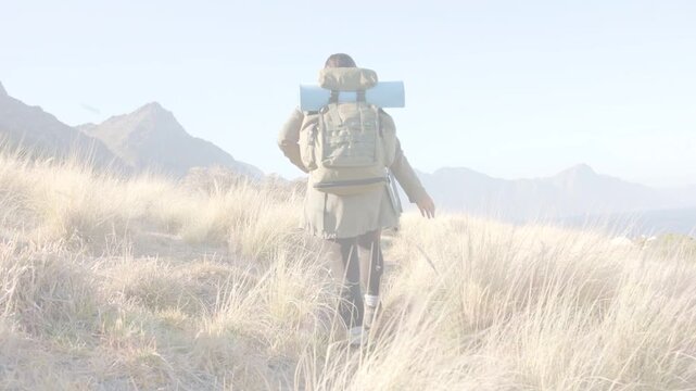 Female hiker following narrow ridge path toward far peaks, travel footage showing backpack blue pad