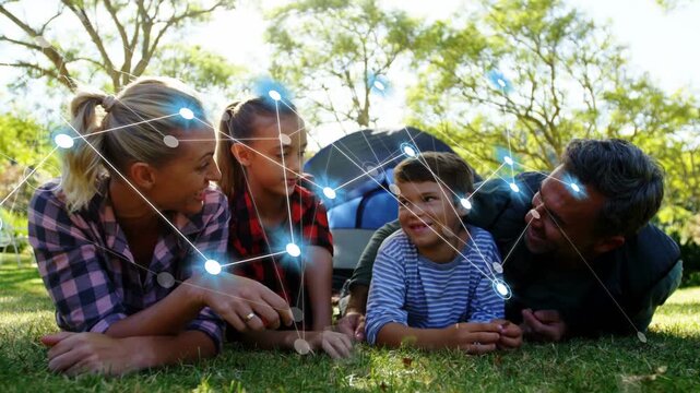 Mother pointing and generating animated blue-node network linking family on grass for tech demo