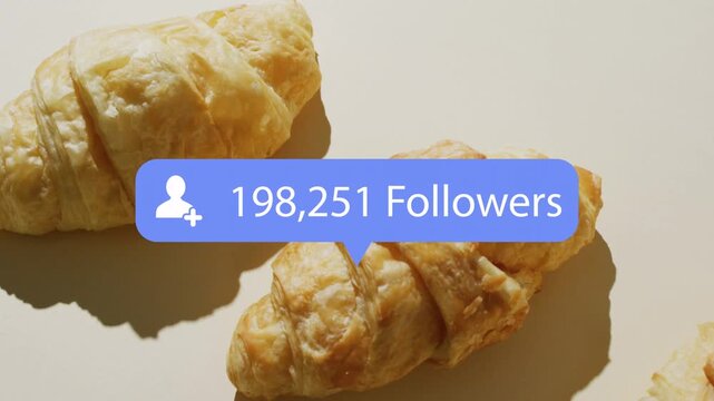 Blue follower badge appearing above left croissant, shifting toward center and counting to million