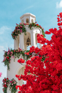 Spring bell tower with sakura blooms and primroses
