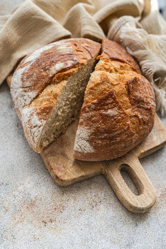 Rustic sourdough bread loaf sliced on wooden board
