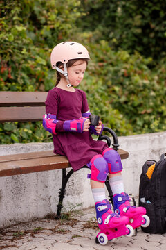 Young girl learning to roller skate at the park