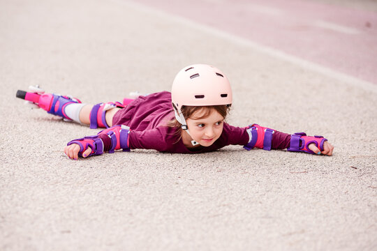 Young girl practicing roller skating with protective gear