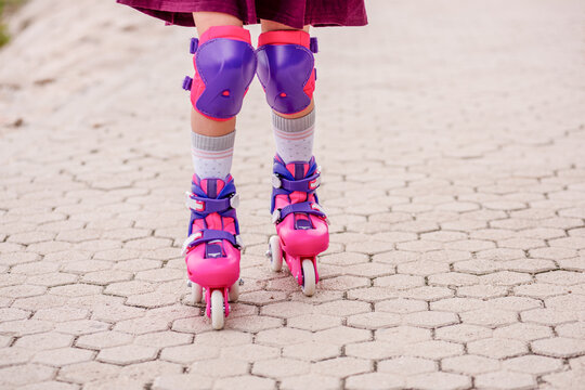 Girl learning to roller skate with protective gear