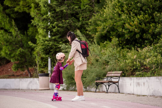 Mother teaching daughter roller skating
