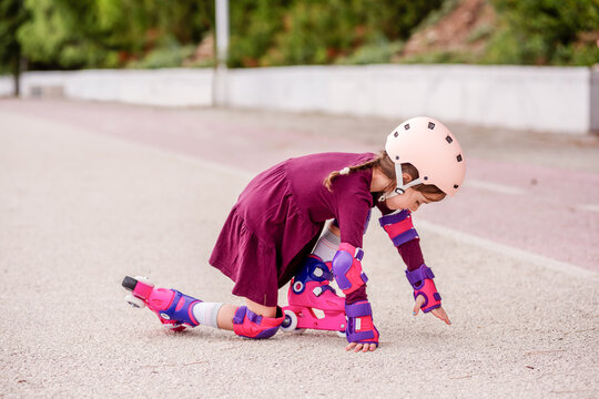 Young girl learning to roller skate safely outdoors