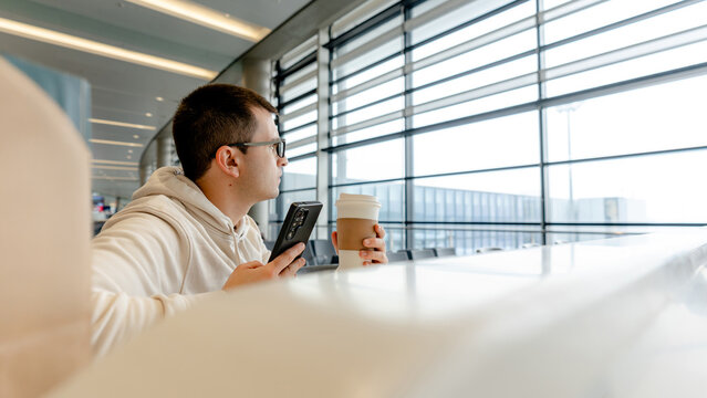 Traveler waiting at airport terminal with coffee
