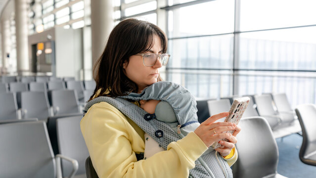 Mother with baby awaits family travel in airport terminal