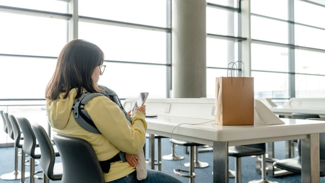 Mother with baby in airport lounge waiting for flight