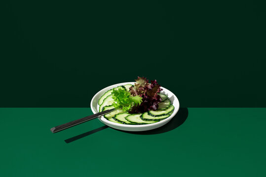 Cucumber and red green lettuce salad on dark background