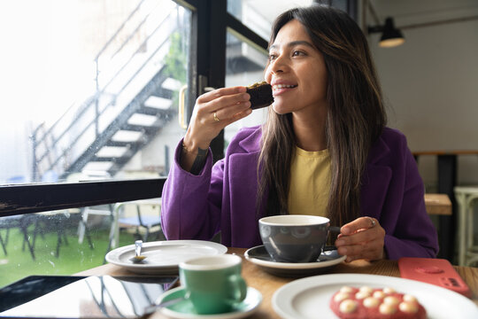 Coffee time in cozy cafe with woman enjoying pastry