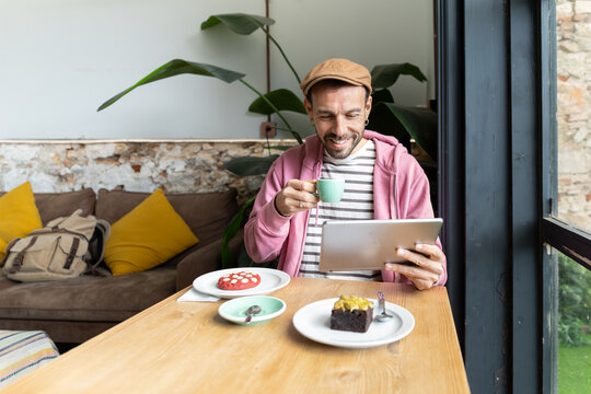 Man enjoying coffee time while using tablet in cafe